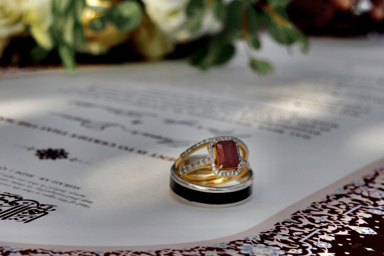 A unique ruby engagement ring nestled inside a contrasting wedding band.