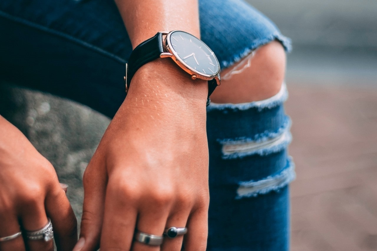 a lady’s hands wearing rings and a luxury watch