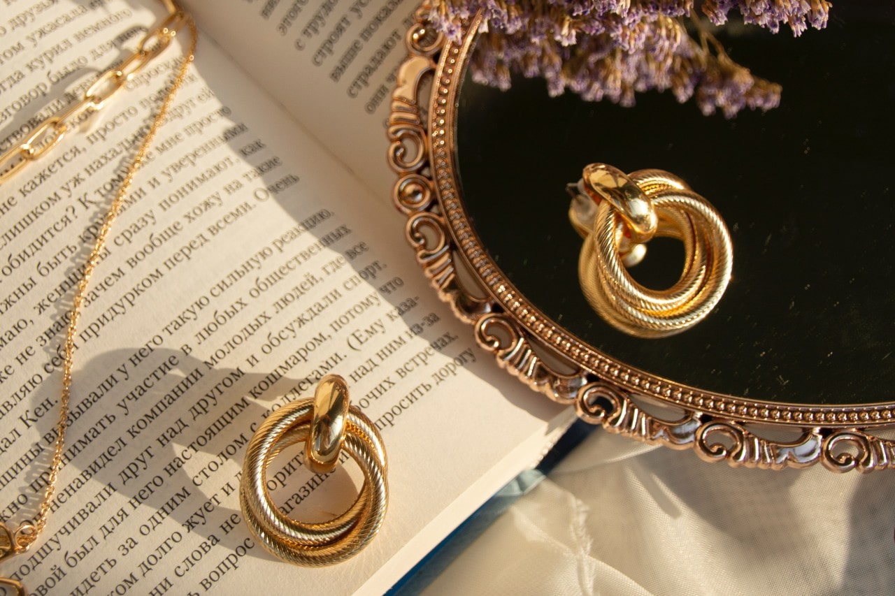 gold jewelry on a table with other objects