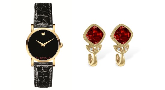 a yellow gold watch with black strap and dial next to a pair of gold earrings with red gems